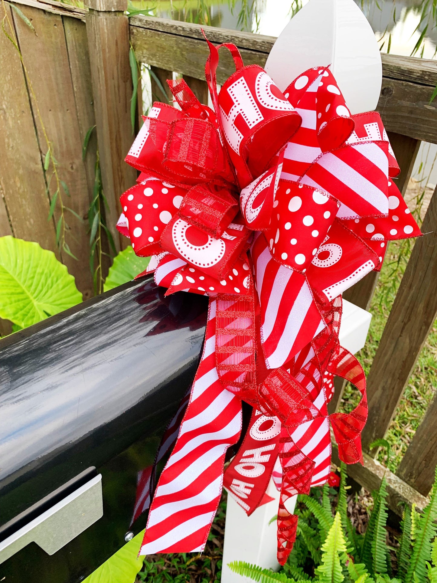 Christmas Bow in Red and White Featuring Santa Claus' Iconic HO HO HO Ribbon. Perfect for Mailbox, Door, and Wreath.