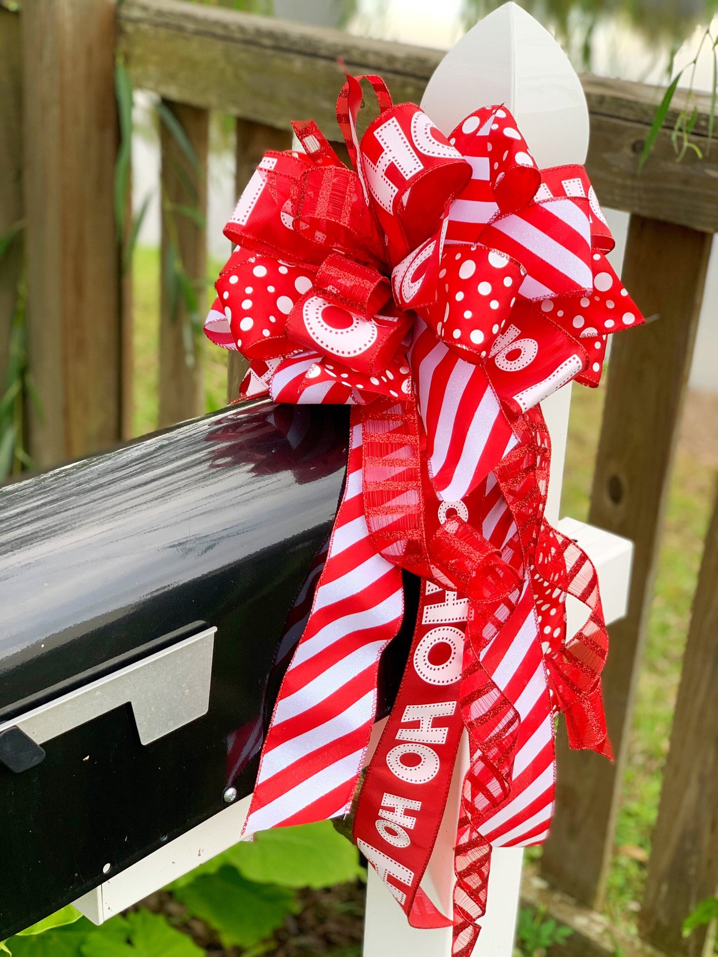 Christmas Bow in Red and White Featuring Santa Claus' Iconic HO HO HO Ribbon. Perfect for Mailbox, Door, and Wreath.
